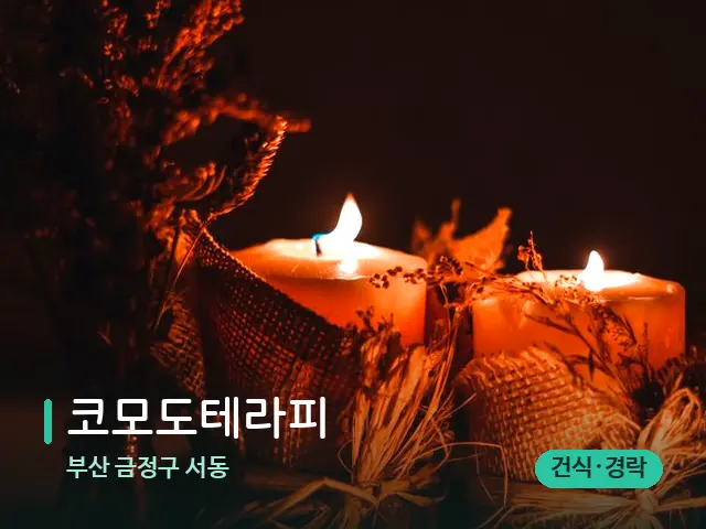 부산 금정구 서동 코모도테라피 — 캔들과 수건이 놓인 스파 소품
